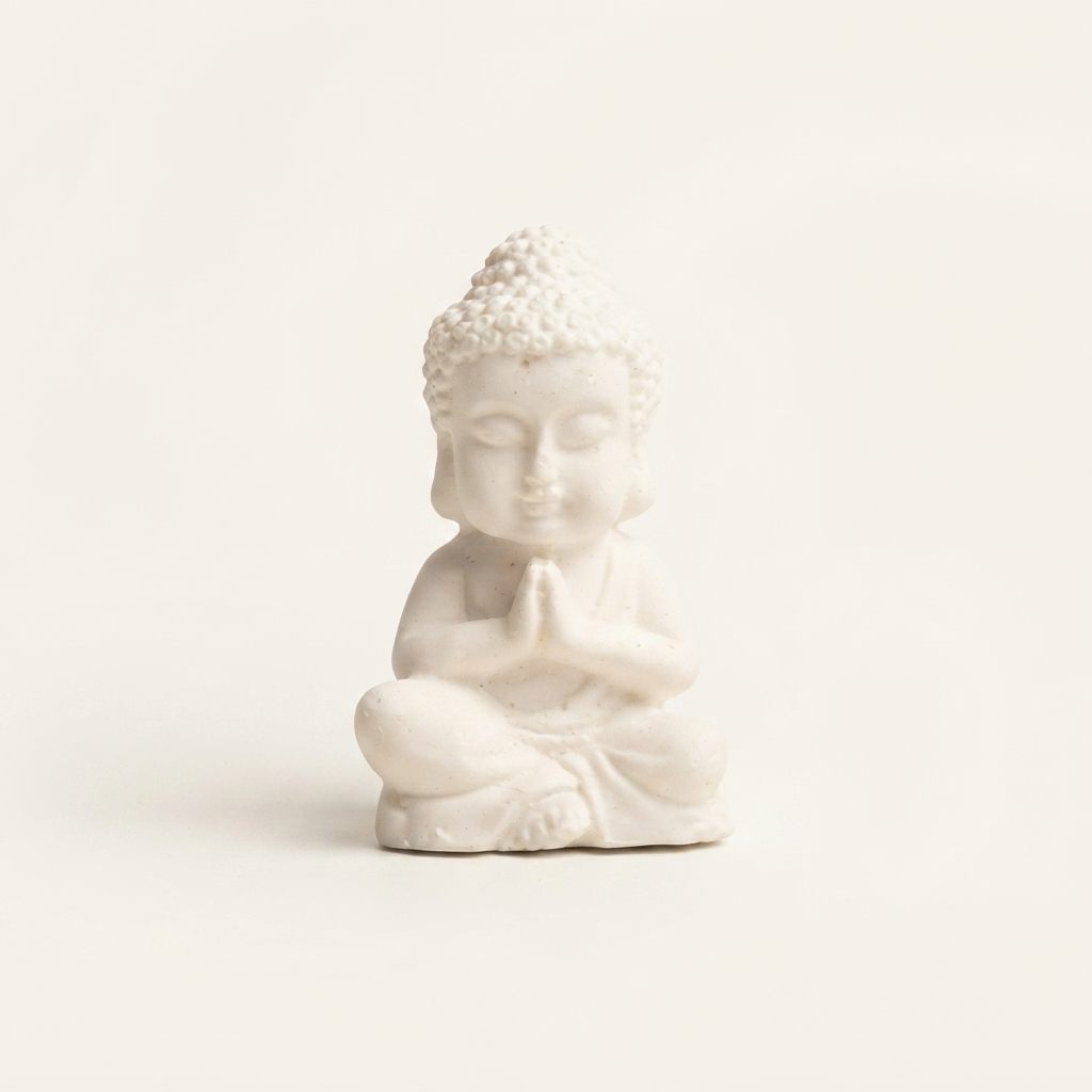 Jabón de coco en forma de buda, en posición de meditación, sobre fondo crudo